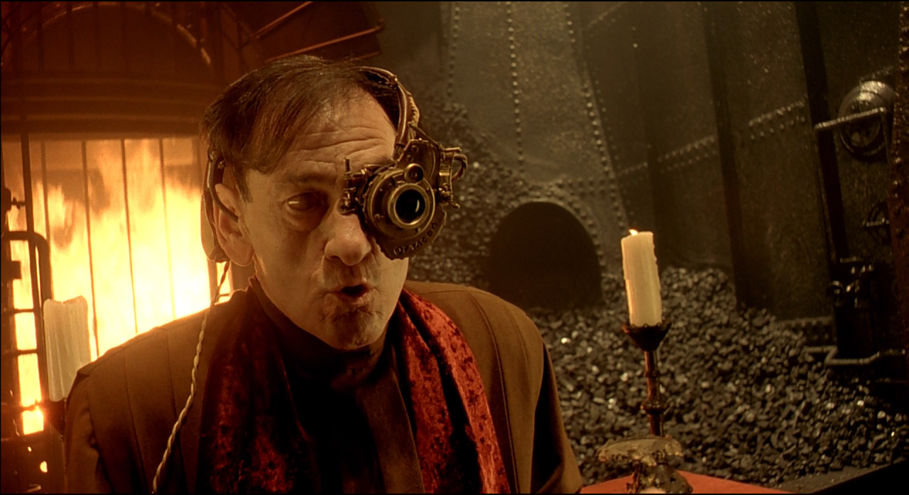 A man using an optical apparatus beside a vivid orange flame.